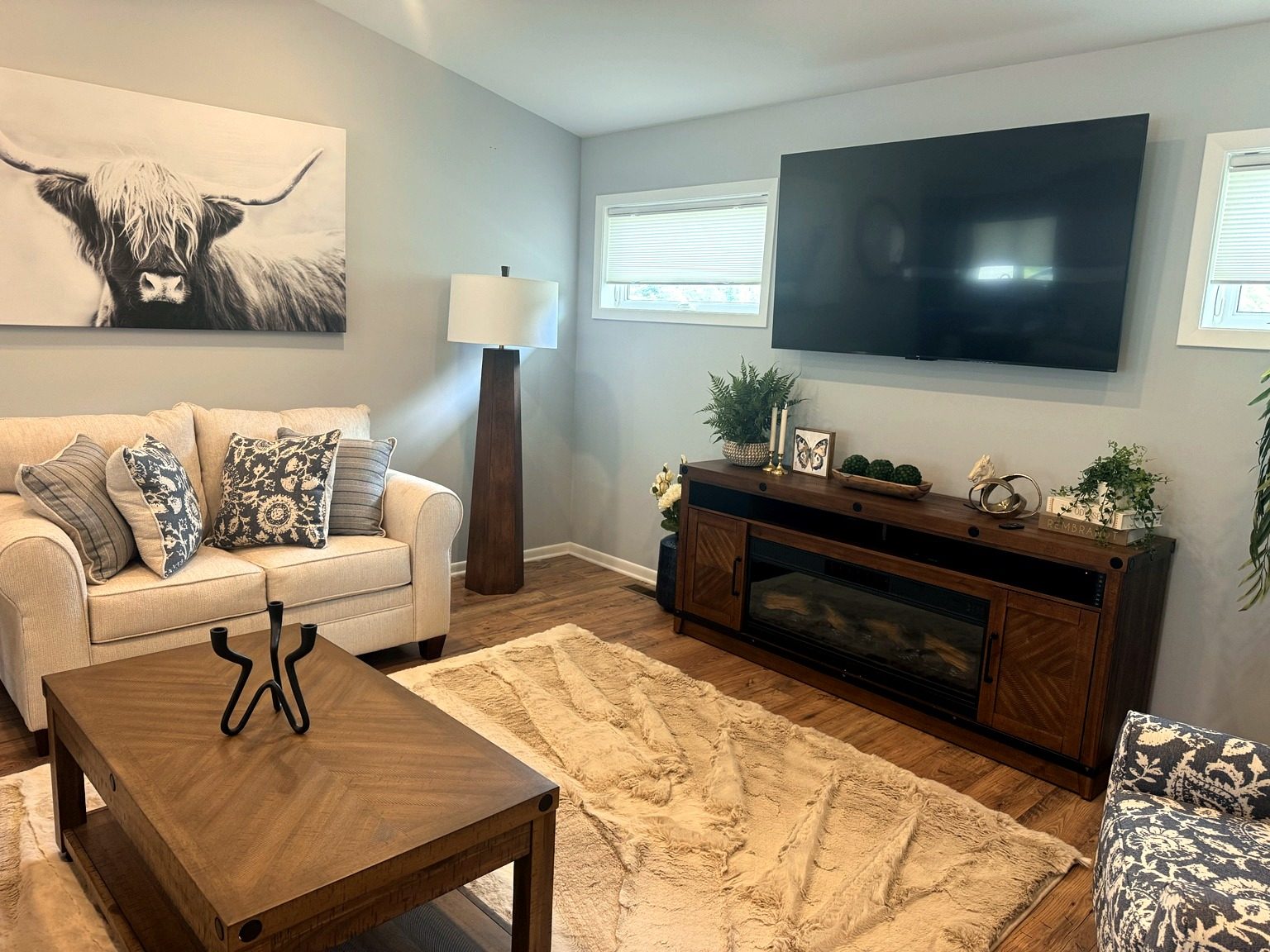 Furnished living room of the one-bedroom home with fireplace and TV
